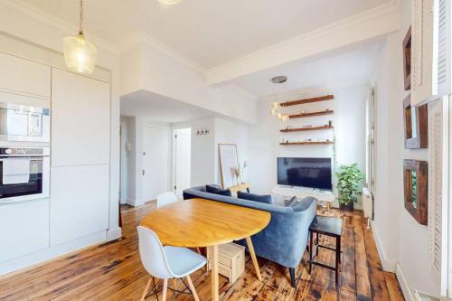 a living room with a table and a blue couch at Modern 1BD flat in Clapham Old Town in London