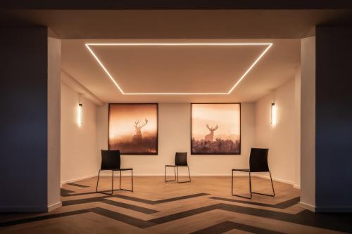 a room with three chairs and three paintings on the wall at Resort Český les in Bělá nad Radbuzou
