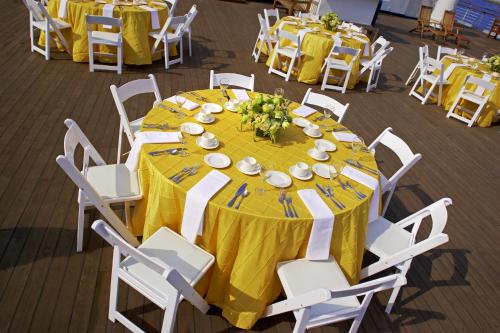 a round table with yellow table cloth and white chairs at The Queen Mary in Long Beach