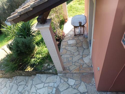 a patio with a stone walkway with a bench on it at Εξοχικό κατάλυμα στο Βιρο Κέρκυρας in Kastanéa