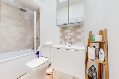 a bathroom with a toilet and a sink and a shower at Modern 1BD flat in Clapham Old Town in London