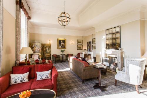 a living room with red furniture and a fireplace at Langrish House in Petersfield