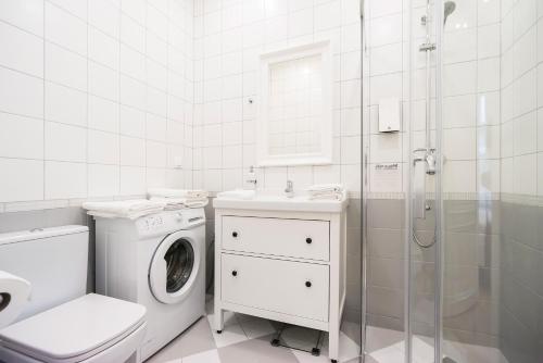 a bathroom with a washing machine and a shower at Revelton Suites Tallinn in Tallinn