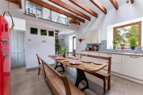 a kitchen with a wooden table and a red refrigerator at Jacobite Lodge by The House of Danu in Kingussie