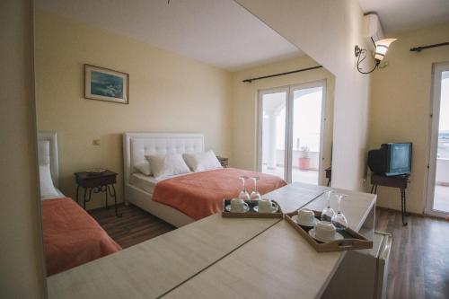 um quarto com uma cama, uma televisão e uma mesa em Mona em Ulcinj