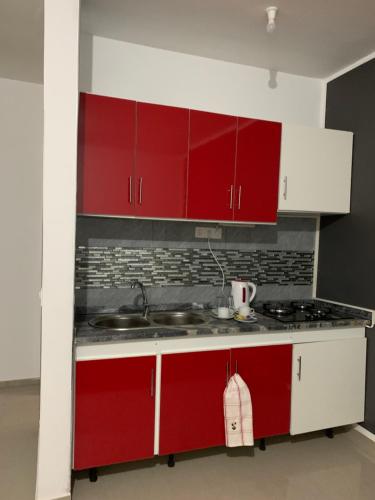 a kitchen with red cabinets and a sink at J Martins Apart Hotel in Tarrafal