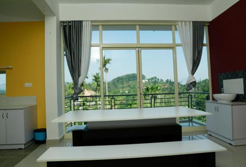 a room with a large window with a view of a balcony at Western Ghats Holiday Home in Kalpetta