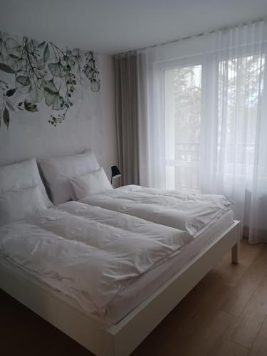 a white bed in a room with a window at APARTMÁN in Turčianske Teplice