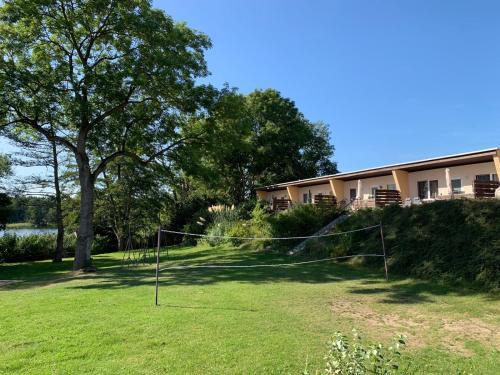 un patio con una red delante de un edificio en Feriendorf Warnabi - Dein Haus am See., en Warin