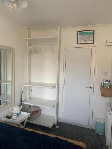 a white refrigerator in a room with a door at Cosy room 10 min from beach in Brighton & Hove