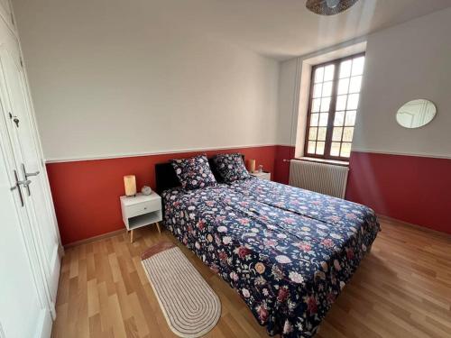 um quarto com uma cama e uma parede vermelha e branca em Maison au pied des Vignes em Vosne-Romanée