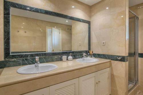 a bathroom with two sinks and a large mirror at modern apartment by the sea.(Marbella) in Marbella