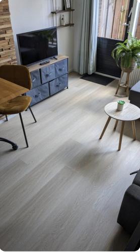 a living room with a television and a table at zomerhuis in Wijk aan Zee! 2 pers in Wijk aan Zee
