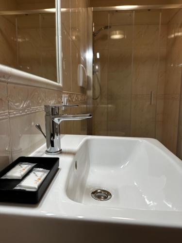 La salle de bains est pourvue d'un lavabo avec miroir et d'une télécommande. dans l'établissement PFA Hotel Viareggio, à Viareggio