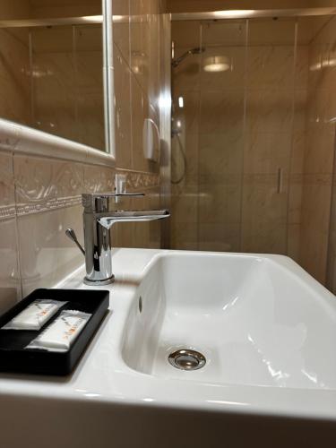 a bathroom sink with a mirror and a remote control at PFA Hotel Viareggio in Viareggio