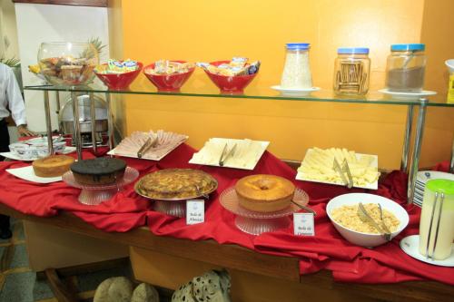 a table topped with lots of different types of food at Terrazzo Hotel in Campos dos Goytacazes