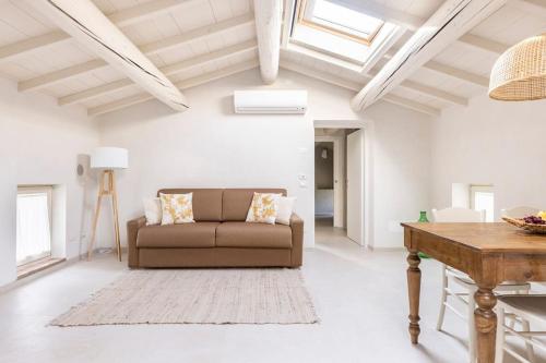a living room with a couch and a table at VerdeOlivo 1876 - Apartments & Pool in Mezzane di Sotto