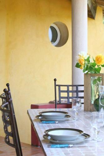 une table avec deux assiettes et un vase avec des fleurs dans l'établissement La Guetteuse, à Hyères