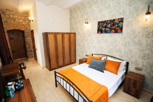 a bedroom with a bed with an orange blanket at Art Hotel by ABAD Guest in Sheki
