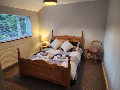 a bedroom with a wooden bed with towels on it at Modern 3 bedroom home in Guildford. Sleeps 8 in Guildford