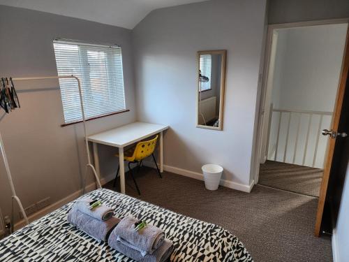 1 dormitorio con cama, escritorio y mesa en Modern 3 bedroom home in Guildford. Sleeps 8, en Guildford