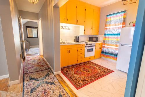 een keuken met gele kasten en een witte koelkast bij New Listing!! Bright Bohemian Stay in Laramie