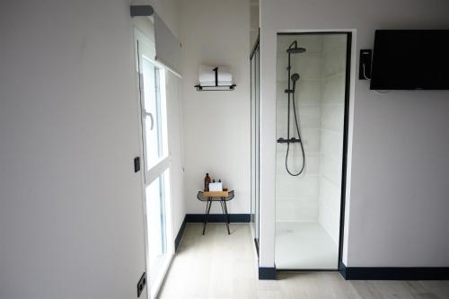 baño con ducha y puerta de cristal en Hotel Neguetxea, en Guernica y Luno