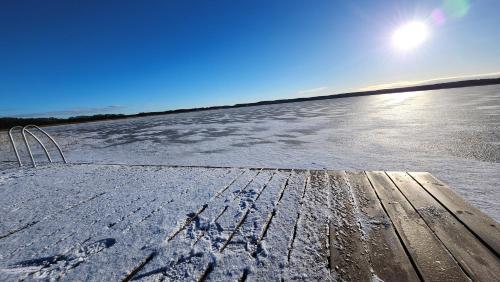 a snow covered field with the sun in the sky at Jak Tu Sielsko in Osiek