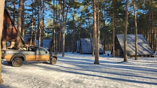 a truck parked in the snow next to a cabin at Jak Tu Sielsko in Osiek