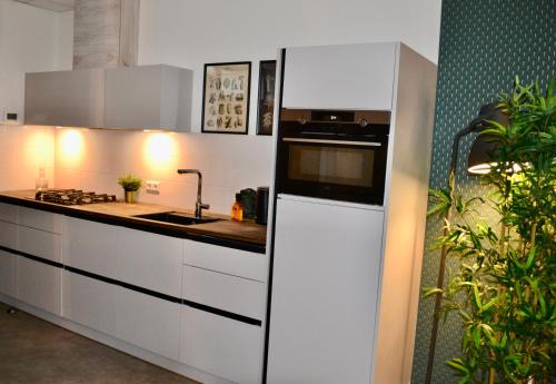 a kitchen with white cabinets and a black and white appliance at The Flowerhouse in Zandvoort