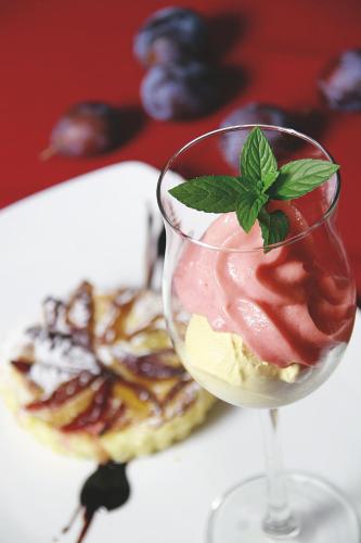 a wine glass with a dessert in front of a plate of food at Hotel Feldwebel in Söll