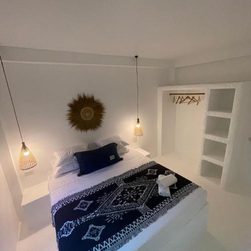 a bedroom with a bed with a blue blanket and lights at Acqualanta House in Ko Lanta