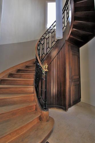 a wooden spiral staircase with a wooden door in a building at Manoir de Montigny in Russy-Bémont