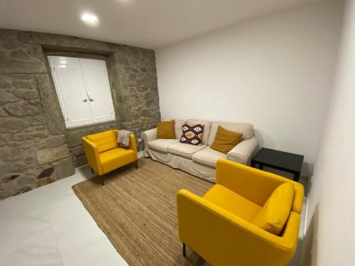 uma sala de estar com um sofá e duas cadeiras amarelas em Casa Bossa Nova no Fundão