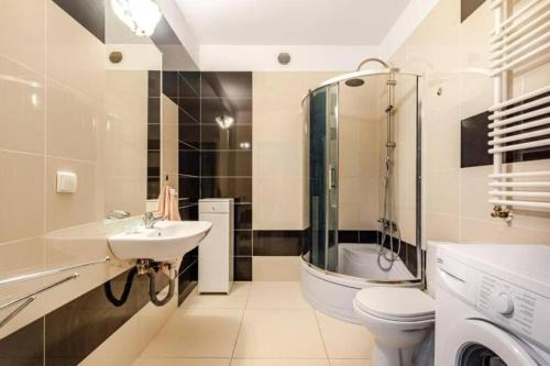 La salle de bains est pourvue d'un lavabo, de toilettes et d'une douche. dans l'établissement Urbannest_Łąkowa, à Gdańsk