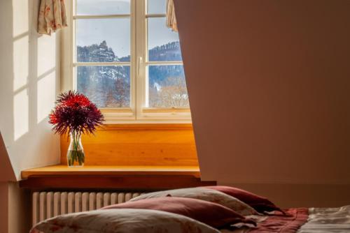 a vase of flowers sitting on a window sill at Pałac Pakoszów Schlosshotel Wernersdorf in Jelenia Góra