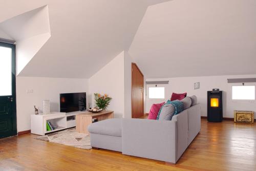 a white living room with a couch and a tv at Casa das Eiras, Nº48 in Santana