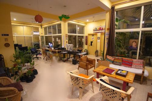 a living room with tables and chairs and a room with windows at Devi music ashram in Rishīkesh
