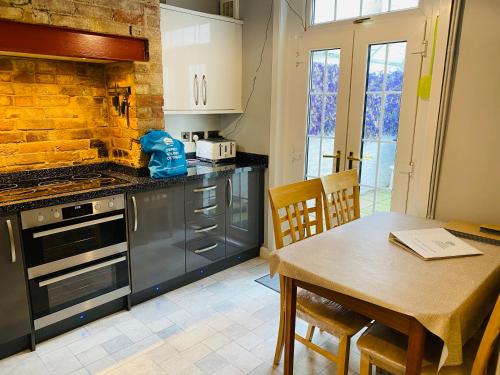 a kitchen with a table and a stove top oven at Green Sails House in Weymouth