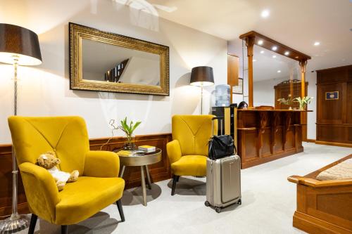 a waiting room with two yellow chairs and a teddy bear at Villa Alvīne Family Apart-Hotel in Jūrmala