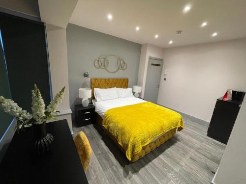 a bedroom with a bed with a yellow blanket at Private Family and Business Rooms Harrow Fast WiFi in Pinner