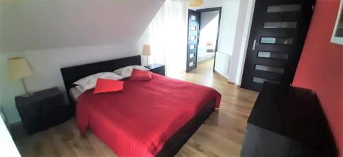 1 dormitorio con 1 cama con manta roja en House between Cracow and Wieliczka en Wieliczka