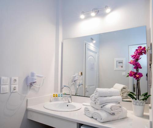 a white bathroom with a sink and a mirror at Cavo D'oro All Inclusive Resort in Kalamaki