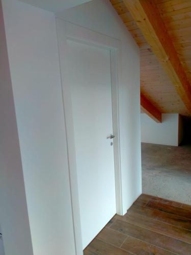 a white door in a room with a wooden ceiling at Villa panoramica sulle colline del Monferrato in Calamandrana