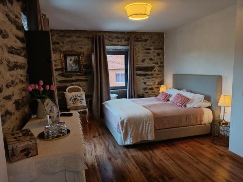 Casa do Romezal في بيسو دا ريجوا: غرفة نوم بسرير وطاولة مع ورد