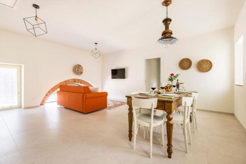 a living room with a table and a couch at VerdeOlivo 1876 - Apartments & Pool in Mezzane di Sotto