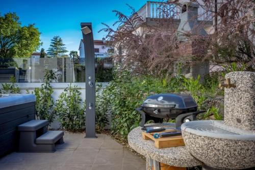 a barbecue grill sitting on a table in a garden at Premium Apartments in Vantačići