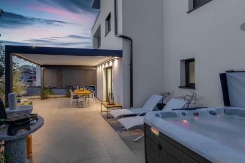 a patio with chairs and a hot tub on a building at Premium Apartments in Vantačići