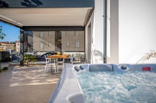 a hot tub on a patio with a table at Premium Apartments in Vantačići
