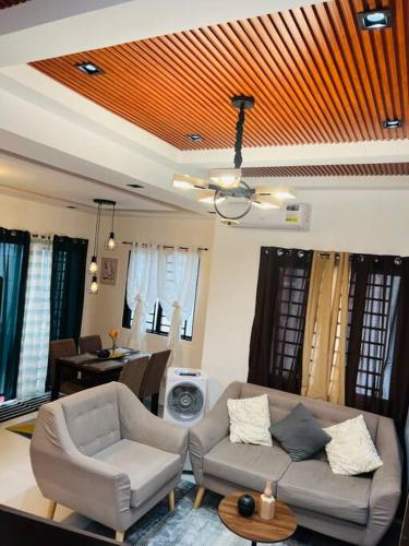 sala de estar con sofá, sillas y mesa en Modern Home and Stylish Design, en Ibaba